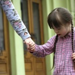 Girl holding arms of the mother on a walk .
