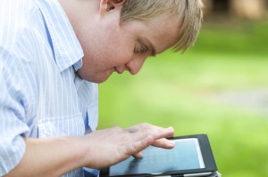 Kid with down syndrome playing on tablet.