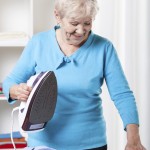 Elderly woman ironing