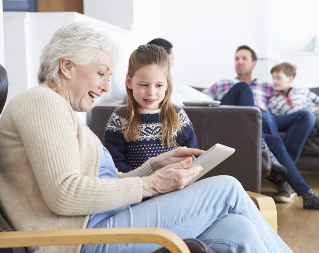 Grandmother And Granddaughter Using Digital Tablet Together