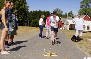 Uteaktiviteter på grusvei med mange mennesker.